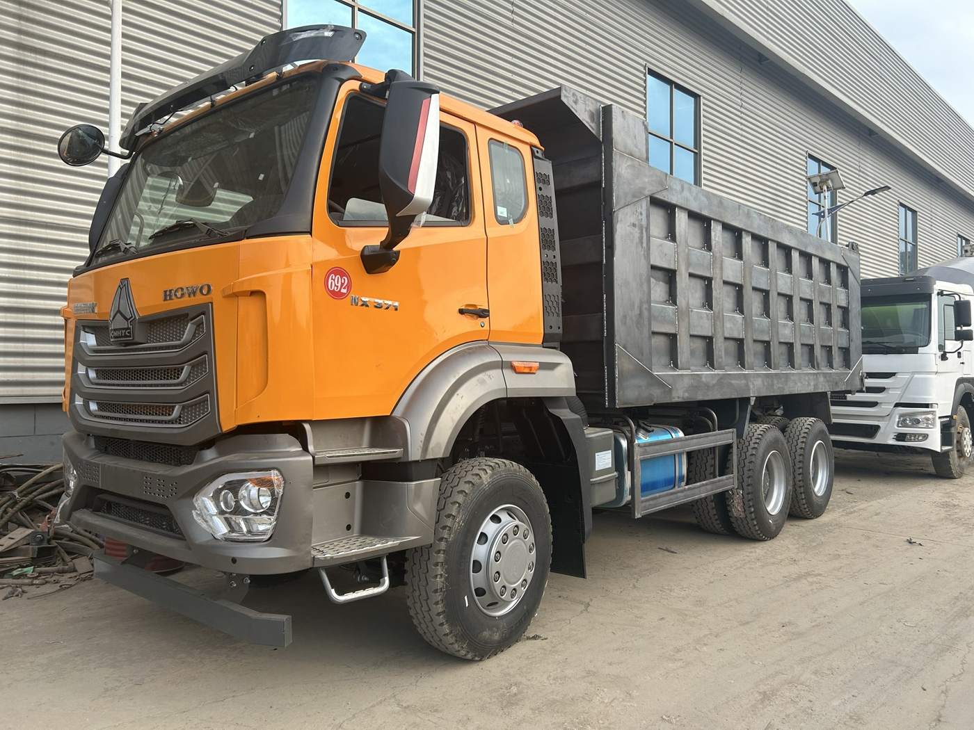 HOWO NX truck standing in our workshop yard — visit us in person